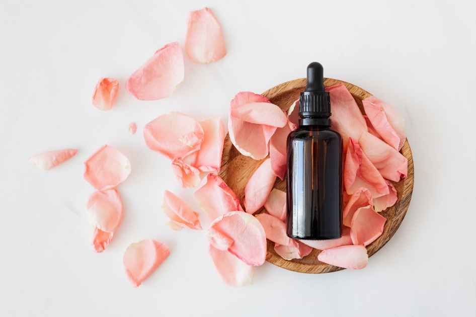 3 Skincare Ingredients for Younger Looking Skin 1 A bottle of serum placed in a wooden container with pink petals