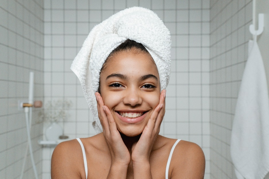 3 Skincare Ingredients for Younger Looking Skin 2  A smiling woman touching her face
