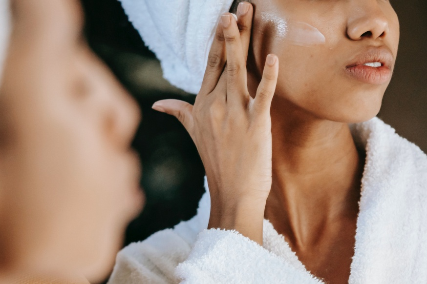 A woman applying a serum on her face