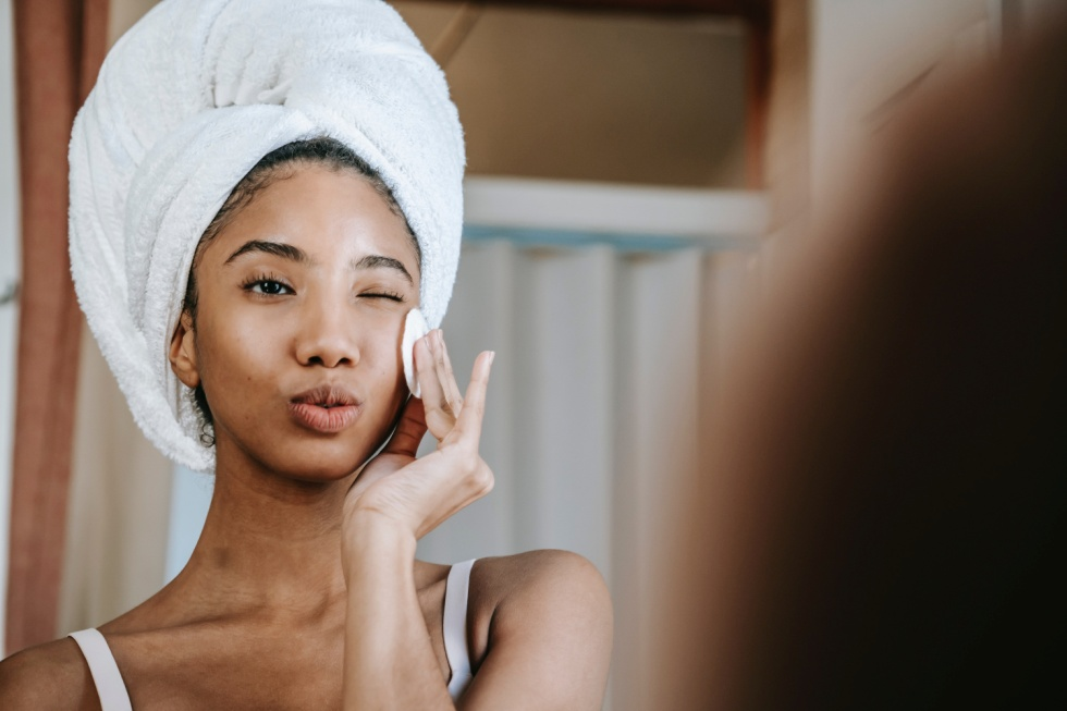 A woman applying a skin care product on her face