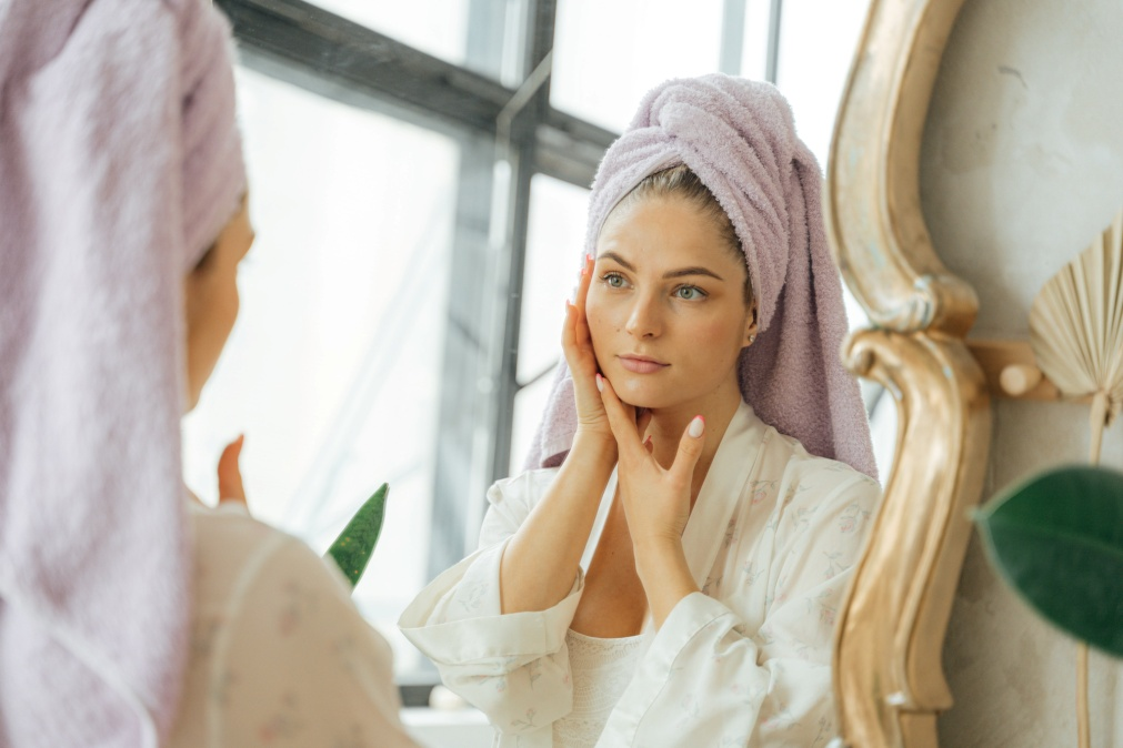 A woman in a bathrobe looking in the mirrorpng