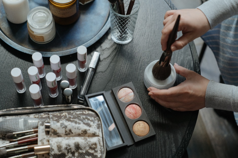Person holding a brush on a makeup table