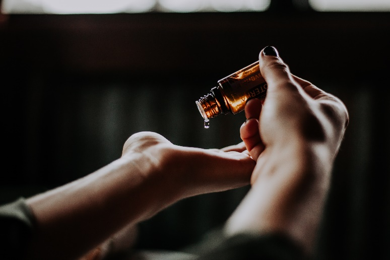 A person pouring serum on their other hand.