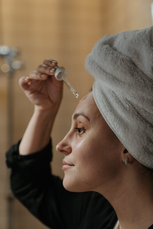 a woman using a facial serum