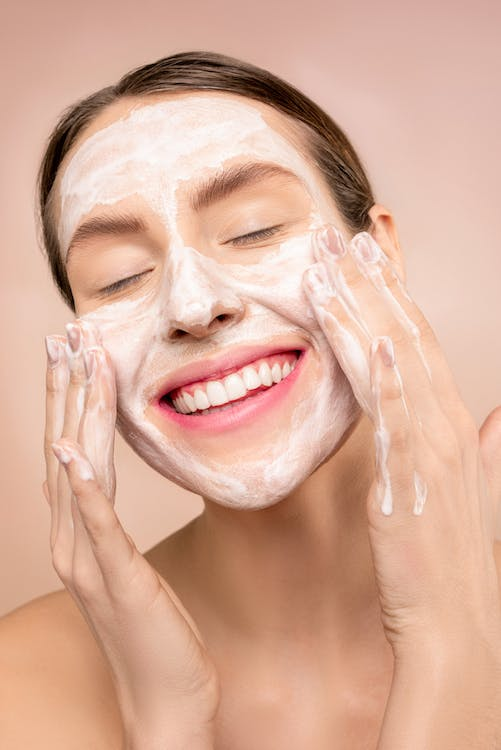 a woman using a skin cleanser