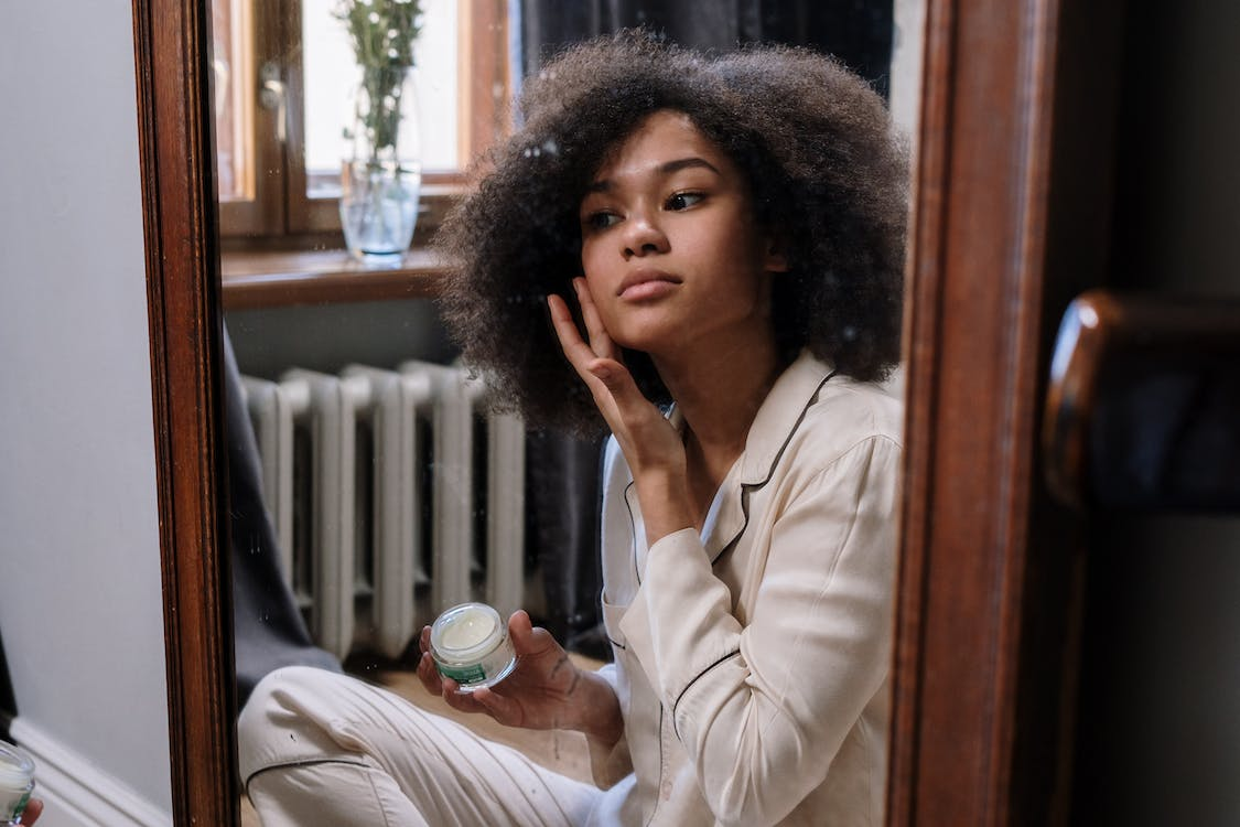 a woman using a skin moisturizer