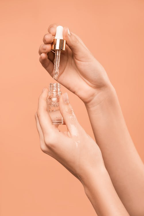 A Close-up Photo of a Woman Applying Facial Cream