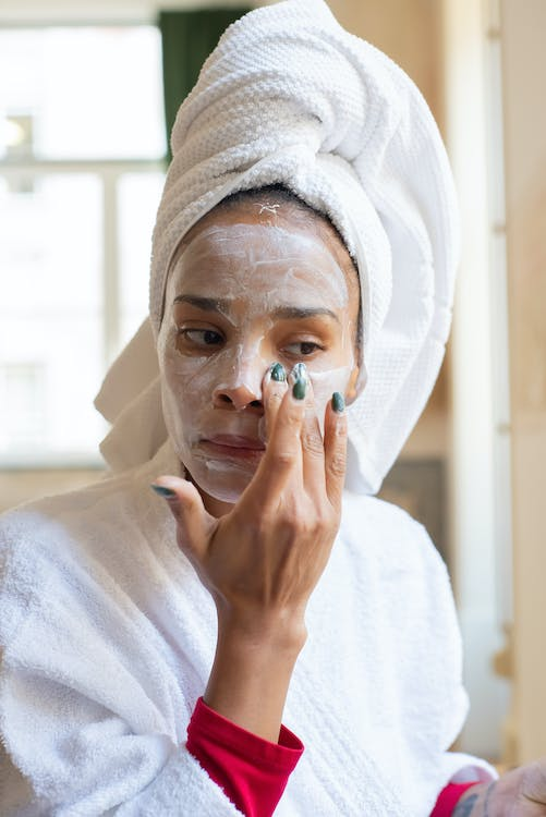 A Woman Applying Cream on Her Face