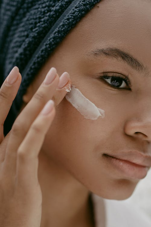 A Woman Putting Face Cream on Cheek